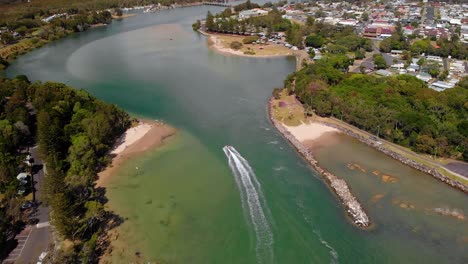Vista-Aérea-De-Drones-Siguiendo-Un-Bote-En-Un-Río-Evans,-En-Nueva-Gales-Del-Sur,-Australia