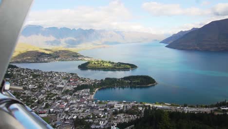 Sliding-reveal-of-Queenstown,-New-Zealand-from-above-at-the-gondola