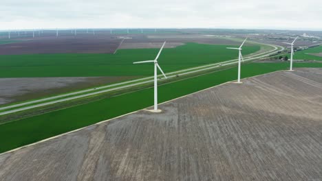 Wind-energy-farm-generating-electricity-in-orbiting-aerial-view