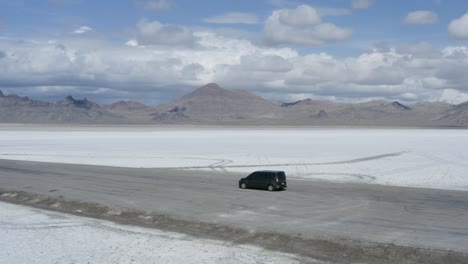Car-parked-on-road-with-epic-salt-flats-landscape-background,-aerial-orbit