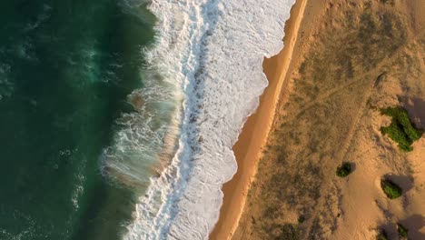Bird's-eye-sky-view-drone-pan-shot-over-coastline-ocean-waves-and-sand-on-Central-Coast-NSW-Australia-3840x2160-4K