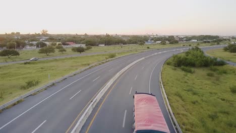 Aerial---light-traffic-on-highway-curve-in-Reynosa,-Mexico,-wide-follow-shot