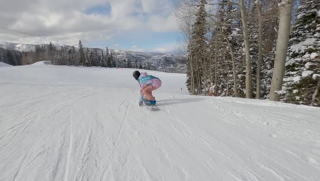 Snowboarder-point-of-view-of-female-performing-ollie-riding-down-slope-fast
