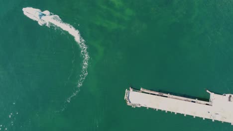Bird's-eye-Drone-view-of-clear-ocean-reef-with-coal-loading-wharf-bridge-and-boat-in-mining-town-Catherine-Hill-Bay-Swansea-NSW-Australia-3840x2160-4K