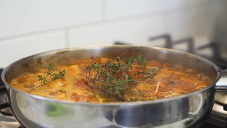 Pan-of-rich-sauce-cooking-and-bubbling-in-pan