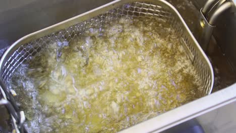 Thick-cut-chips-being-dunked-into-deep-fat-fryer