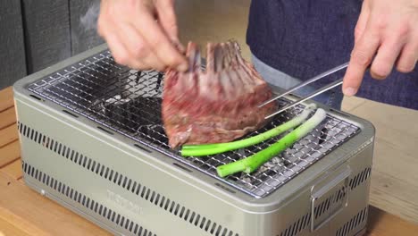 Placing-large-fillet-of-lamb-on-outdoor-hibachi-grill
