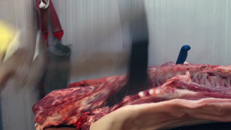 Butcher-with-an-ax-slices-pork-ribs-on-a-butcher-table