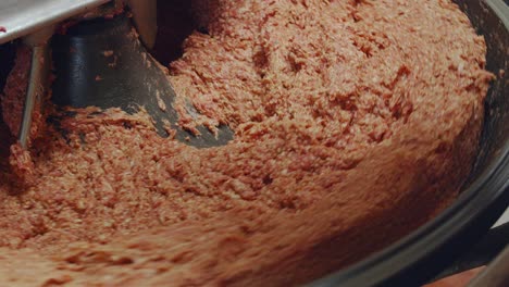 Butcher-checks-the-quality-of-the-minced-meat-in-the-mixing-machine-Close-up