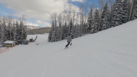 Man-snowboarding-down-a-mountain-slope