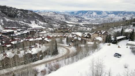 Aerial-drone-shot-of-ski-resort-area-in-Aspen,-Colorado-with-mountains-in-background