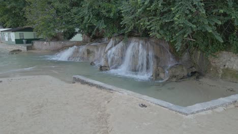 Dunn's-River-Falls-empties-into-Caribbean-Sea-by-scenic-white-sand-beach-Jamaica