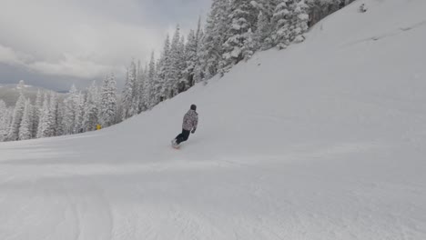 Snowboarder-Spin-And-Ollie-Die-Hänge-Von-Aspen,-Colorado-Hinunter
