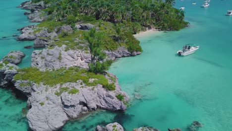 Bermuda-panning-drone-shot-of-rock-formations-and-a-boat-in-clear-shallow-water-near-Morgan's-Island