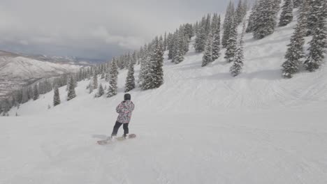 Point-of-view-follow-snowboarder-slide-down-on-ski-slope-at-ski-resort,-Aspen,-Colorado