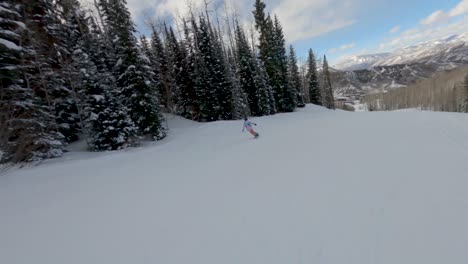 Mujer-Snowboarder-Realizando-Un-Ollie-Y-Continuar-Cuesta-Abajo,-Aspen,-Colorado