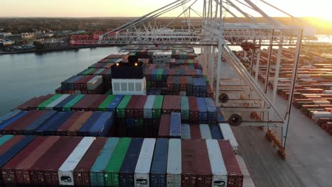 Top-down-aerial-drone-shot-flying-over-container-ship-in-port-unloading-containers
