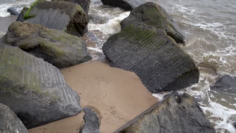 Reihe-Von-Großen-Felsbrocken-Am-Strand,-Ausgekleidet-Ins-Meer-Am-Strand-Von-Waxham-Sands,-Norfolk,-Großbritannien