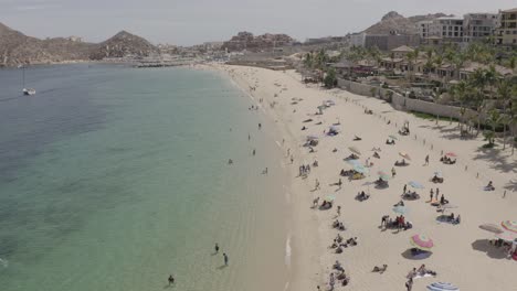 People-enjoying-Medano-Beach-shoreline,-Cabo-San-Lucas,-Los-Cabos,-México