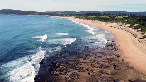 Beautiful-aerial-drone-scenic-pan-view-of-rocky-sand-coastline-of-Shelly-Beach-Central-Coast-tourism-NSW-Australia-3840x2160-4K
