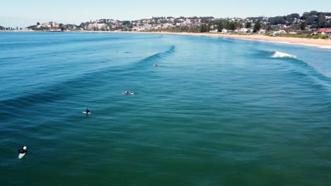 Drone-aerial-shot-of-surfers-waiting-for-waves-and-line-up-along-Terrigal-Beach-The-Bend-Pacific-Ocean-Central-Coast-NSW-Australia-3840x2160-4K