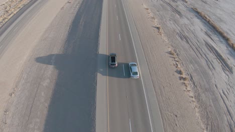 Two-cars-driving-along-Desert,-Las-Vegas,-Nevada