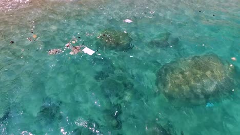 Gemischter-Müll-Schwimmt-Im-Wasser-Nahe-Dem-Strand-Und-Korallen-Schießen-Stetig-Von-Oben-1080-Hd-Asien,-Thailand-Gefilmt-Mit-Sony-Ax700