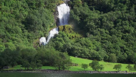 One-of-the-many-beautiful-waterfalls-of-the-Naeroyfjord,-hidden-in-the-forest-covered-mountainside