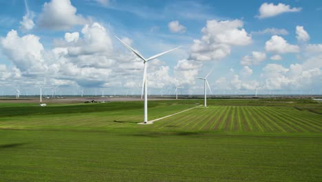 Medium-shot-of-Wind-turbines-spinning-in-slow-motion-on-a-blue-summer-day-over-a-green-field-in-Texas