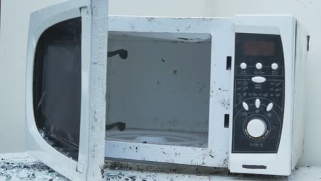 Slow-Motion-Of-Smashing-Old-Microwave-Oven-With-A-Metal-Hummer