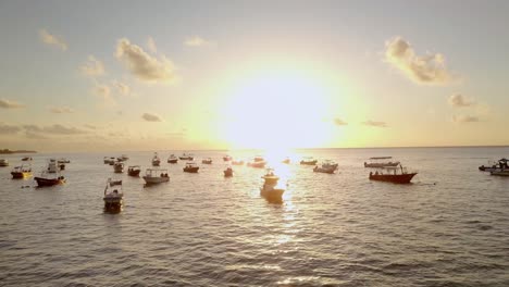 AERIAL---Boats-anchored-at-sunrise-off-the-coast-of-Cancun,-Mexico,-rising-shot