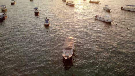 AERIAL---Boats-anchored-at-sunrise,-coast-of-Cancun,-Mexico,-descending-shot