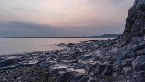 Timelapse-of-Sun-setting-bellow-horizon-across-sea-at-Ogmore-on-Sea,-South-Wales,-UK