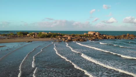 Aerial-view-over-waves-and-shallow-water-at-a-beach,-in-Bowen,-Australia---pull-back,-drone-shot