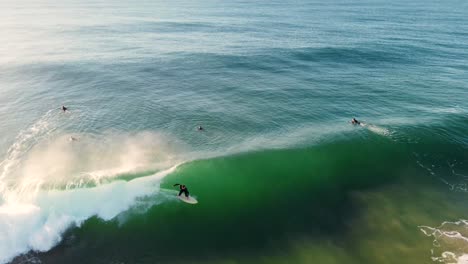 Drone-aerial-shot-of-surfer-riding-ocean-wave-sand-bar-beach-break-North-Entrance-Central-Coast-tourism-NSW-Australia-4K