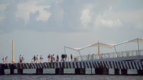 People-walking-in-the-pier-on-a-beautiful,-sunny-day-in-Cancun,-Mexico