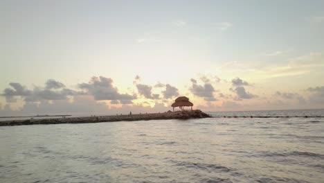 AERIAL---A-cabana-in-rocky-pier-at-dawn,-Cancun,-Mexico,-wide-forward-shot