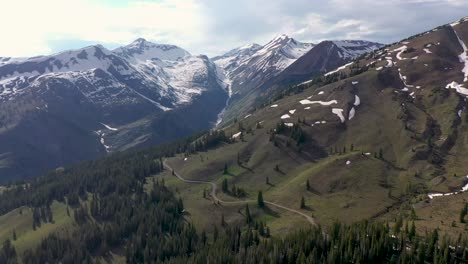 An-aerial-view-of-remote-mountains-and-forest-in-Colorado-along-the-Continental-Divide-with-a-rocky-mountain-pass-seen-below
