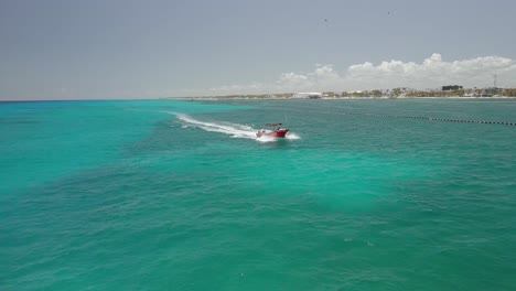 AERIAL---Boat-speeding-through-the-beautiful-turquoise-waters-of-Cancun,-Mexico
