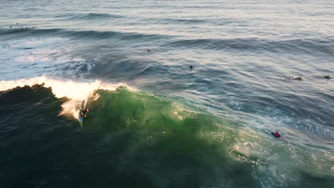 Drone-aerial-shot-of-surfer-riding-doing-cutback-ocean-wave-beach-break-sand-bar-Pacific-Ocean-North-Avoca-Central-Coast-NSW-Australia-4K