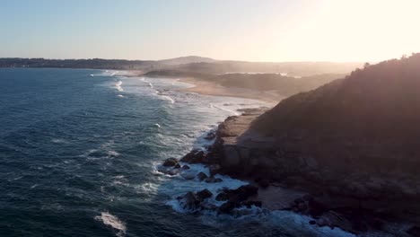 Drone-aerial-shot-of-later-afternoon-Spoon-Bay-Wamberal-Beach-Afternoon-Sunset-along-Pacific-Ocean-Beach-Central-Coast-NSW-Australia-4K