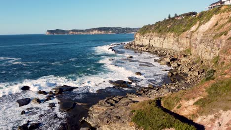 Drone-aerial-pan-shot-of-North-Avoca-and-Terrigal-Headland-on-the-Central-Coast-Pacific-Ocean-Waves-Tourism-NSW-Australia-4K