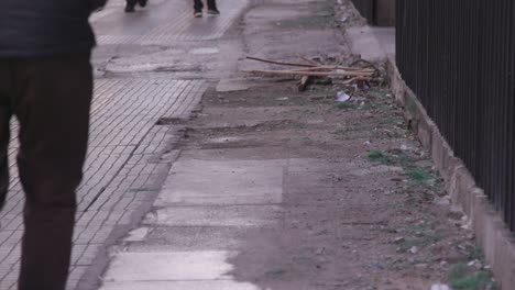 Dirty-ground-and-people-walking-by-in-the-center-of-Athens,-Greece