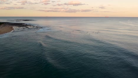 Drone-Sky-Shot-De-Shelly-Beach-Tarde-Puesta-De-Sol-Con-Surfistas-Océano-Pacífico-Costa-Central-Nsw-Australia-4k