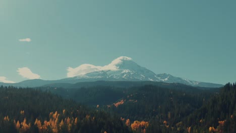 4k-aerial-snowy-mountain-in-fall-with-colorful-forest-in-foreground