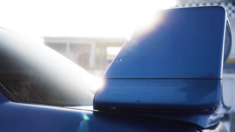 Sport-rally-blue-car-rear-spoiler-with-sun-shine-in-the-background-during-sunny-winter-day