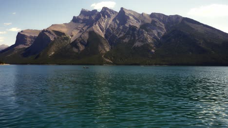 Lago-Minnewanka-Con-Vistas-A-La-Montaña-Y-Un-Pueblo-Remando-En-Una-Canoa-En-El-Fondo