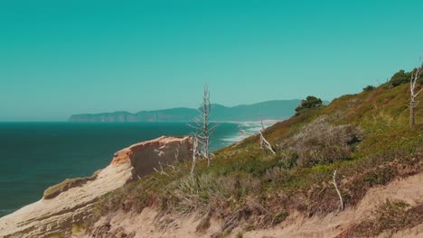 4k-Aerial-Oregon-beach-with-rocky-hills-in-foreground-Drone-jib-up