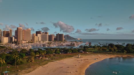 Pull-back-aerial-shot-of-Waikiki-Skyline-with-Diamond-Head-in-the-background-and-Ala-Moana-Beach-Park