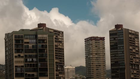 Views-from-an-apartment-a-zoomed-detailed-shot-with-clouds-passing-by-3-apartment-buildings-in-a-hawaii